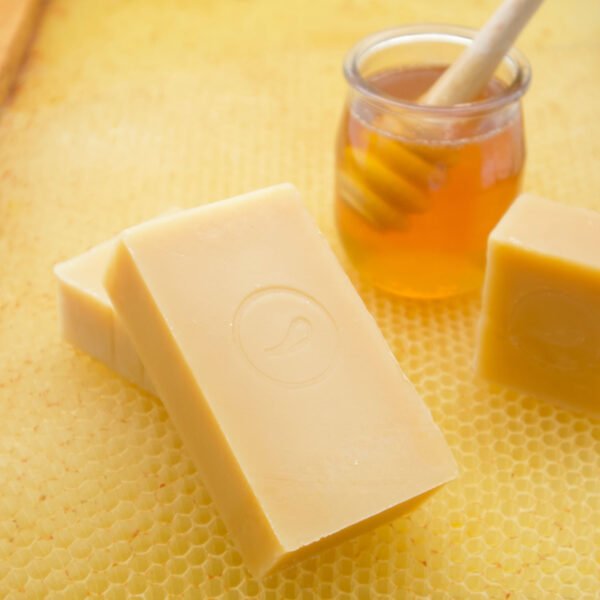 savon au miel sur une feuille de cire et à côté d'un pot de miel
